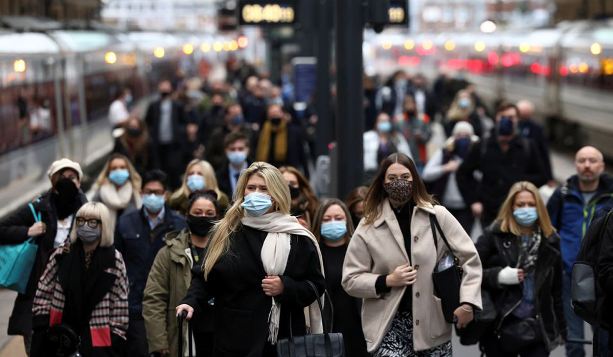 People walk along a platform at Kings Cross train station during morning rush hour